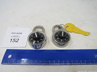 Both Master padlocks beside ruler for scale