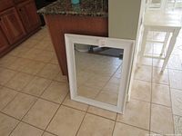 Front view of rectangular mirror with white frame