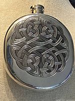 front view of pewter hip flask showing full embossed Celtic knot design