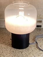 Lamp illuminated showing gradient frosted shade and black base