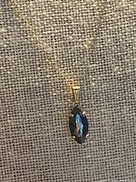 Full view of 10K gold necklace and pendant on display stand