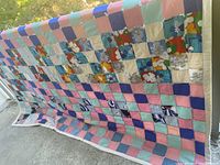 Full view of quilt draped to show overall checkerboard pattern and white border