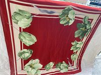 Full view of scarf showing red center, cream border, green floral print