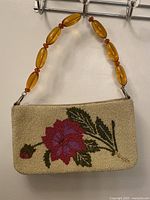 Front view showing full floral bead design and lucite handle