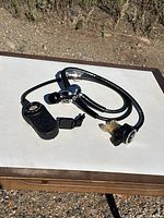 Overall view of regulator assembly showing first stage, hoses, second stage, and gauge