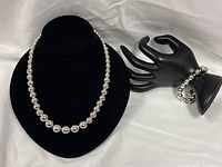 Necklace on display bust, bracelet on mannequin hand