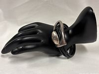 Bracelet displayed on hand form showing sterling clasp and leather cords