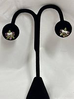 Pair of amethyst and enamel flower earrings on display stand