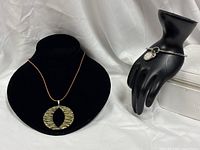 Necklace on display bust, bangle on mannequin hand