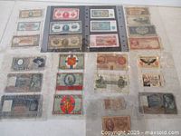 Overall view of 26 assorted world banknotes in plastic album sleeves