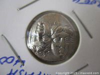 Obverse view showing two inverted youth heads