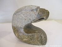front three-quarter view of stone eagle head carving
