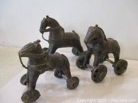 All three bronze wheeled horses