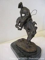 Front left view of bronze cowboy on rearing horse mounted on marble base