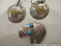 Front of earrings and brooch showing design and stones