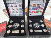 Both open display cases showing stamp panes and medallions