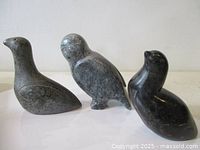 Front view of three soapstone bird carvings