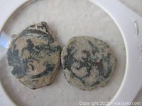 Close-up of both worn coins showing irregular shapes and patina