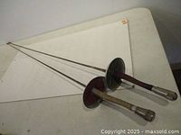 Both fencing swords full view on table