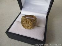 Ring in display box showing face with AA logo and wording