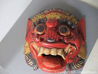 Front view of carved red Barong mask showing overall design
