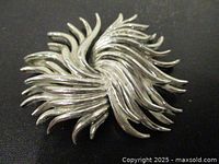 Front view of silver-tone swirl brooch