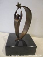 Full view of bronze sculpture on marble base