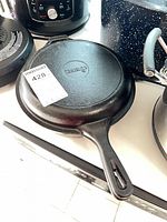 Two stacked Cuisinel cast iron skillets showing embossed brand and handle design