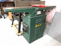 Front left view of green Craftex B706N jointer on cabinet with red blade guard and dust port