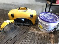 Yellow Wagner carrying case next to face shield and drywall compound bucket
