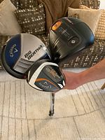 Three golf woods heads close-up showing branding and wear