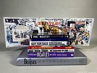 Stack of five Beatles-related hardcover books and folded collage insert
