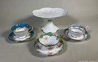Group shot showing pedestal plate and three teacup/saucer sets