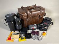 Group shot of entire lot including cameras, lens, flash, bag and accessories