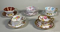 Five teacup and saucer sets laid out