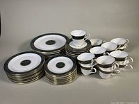 Full set of stacked dinner, luncheon and dessert plates with grouped teacups and saucers
