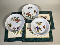 Overview of three Royal Worcester dishes on four placemats