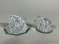 swan and bear figurines on mirrored bases