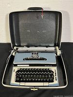 Open Eaton Viking Deluxe 12 typewriter seated in its hard carrying case with key visible