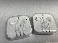 Both EarPods cases closed showing earbuds and remotes
