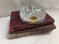 Paperweight on top of two hardcover books showing titles and overall lot