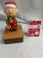 Front view of Charlie Brown figure on base with tag visible