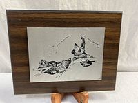 Front view of plaque showing engraved squirrels and wood-grain backing