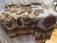 Both tablecloths draped side by side showing overall designs