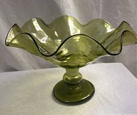 Angled view showing ruffled rim and pedestal base