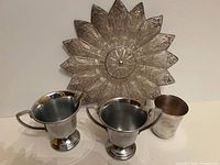 Group shot of all four items: filigree plate, Farberware creamer and sugar bowl, Napier baby cup