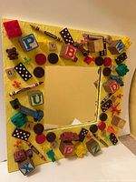 Front view of square mirror showing full decorated frame and mirror glass