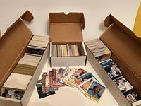 Overview of three boxes of baseball cards with loose sample cards in front