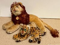 Lion and tiger cub plush toys side by side on carpet