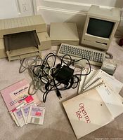 Overall view showing computer, external drive, printer, keyboard, mouse, cables, manuals and disks